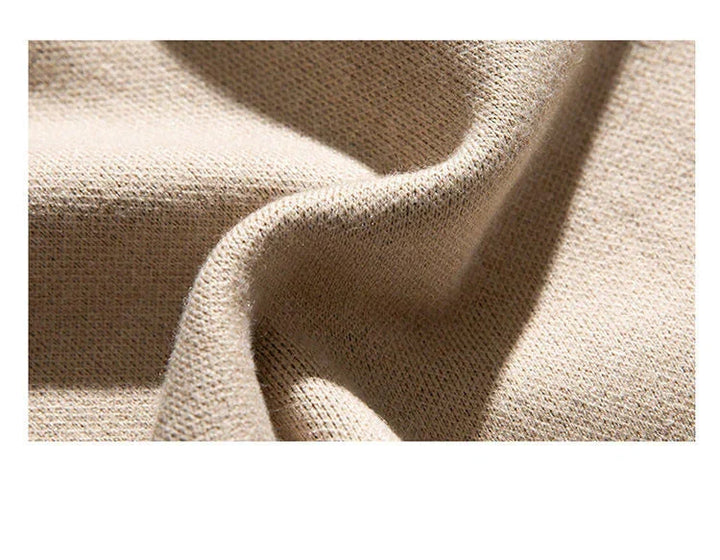 Unisex cat sweater fabric detail, beige knit texture near crew neckline