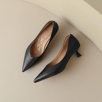 Pair of black pointed-toe pumps with beige insoles, low block heel