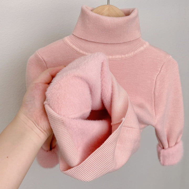 Pink fleece-lined knit sweater with ribbed turtleneck; plush lining exposed in sleeve