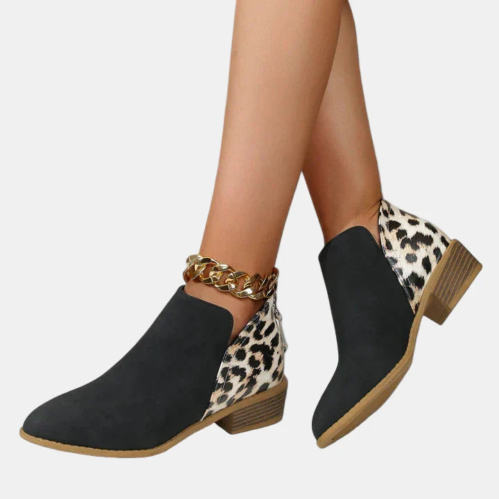 Black ankle boots with leopard-print side panels, gold chain detail, and block heel