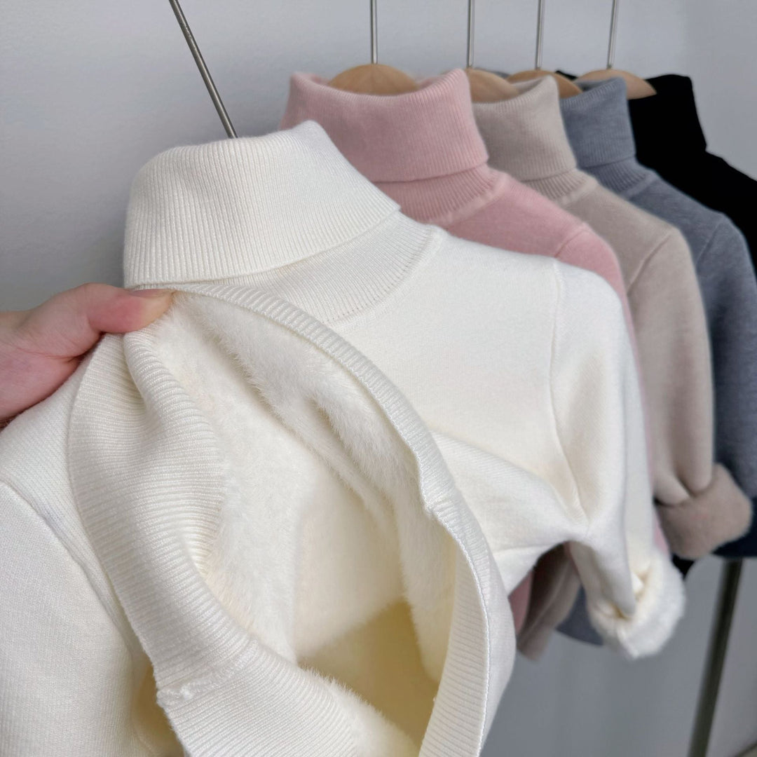 White fleece-lined knit sweater, ribbed turtleneck; plush lining visible at cuff