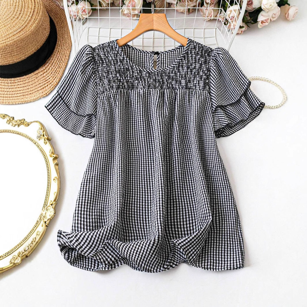 Black-and-white checkered flowy blouse with puff sleeves and smocked round neckline
