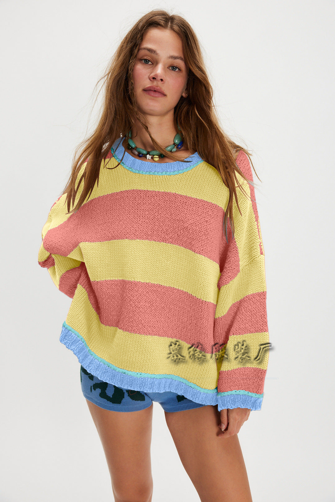 Striped crew neck sweater in pink, yellow, and light stripes with ribbed cuffs and hem.