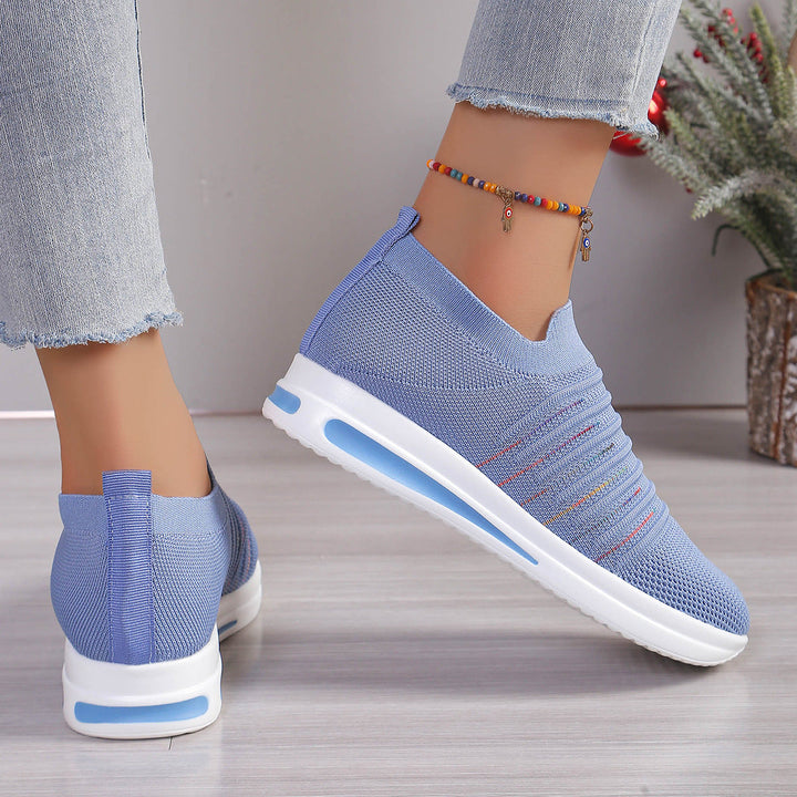 Blue knit slip-on sneakers with multicolor stripe detail, rear and side view, white sole