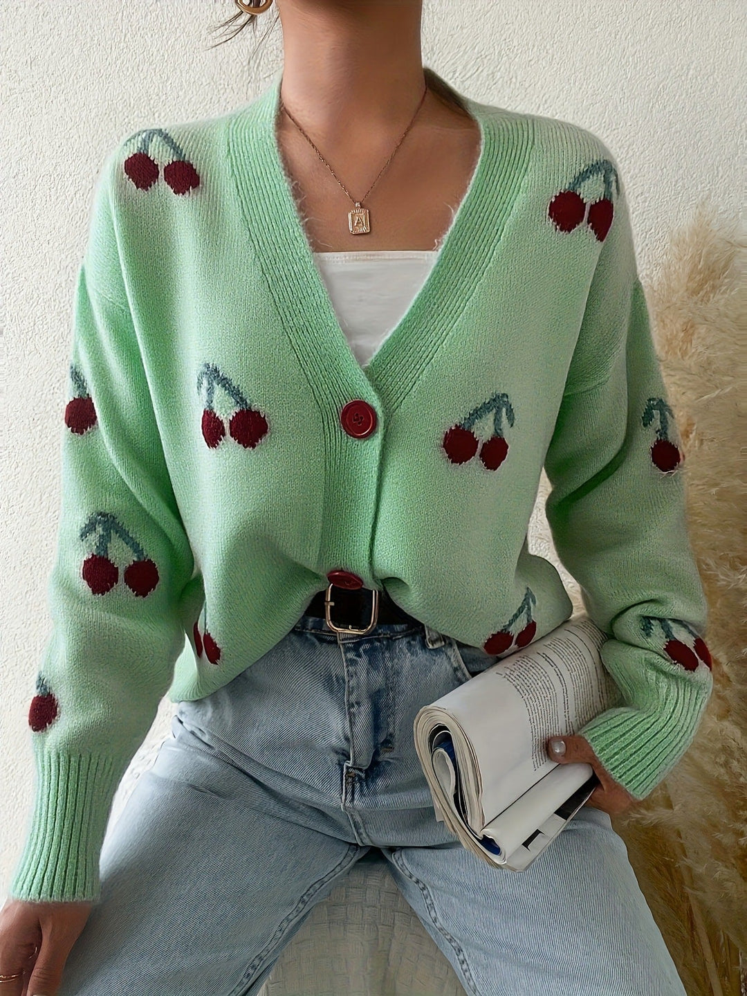 Light green button-front cardigan with red cherry print and ribbed cuffs