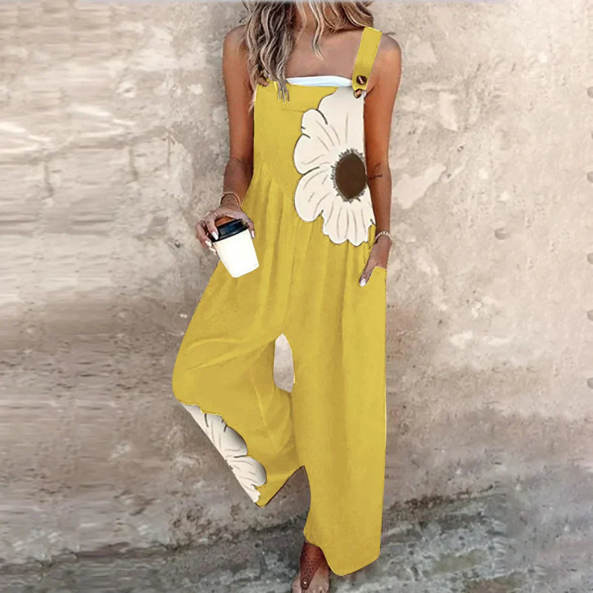 Yellow sleeveless overalls with white daisy print and wide-leg loose fit.