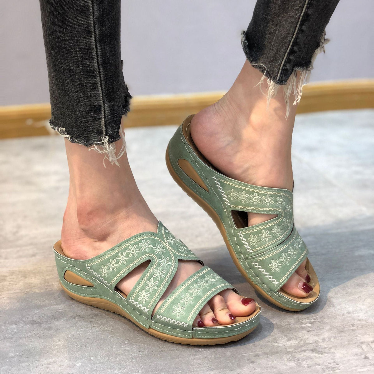 Orthopedic sandals in green with floral stitching, open toe and cushioned sole.