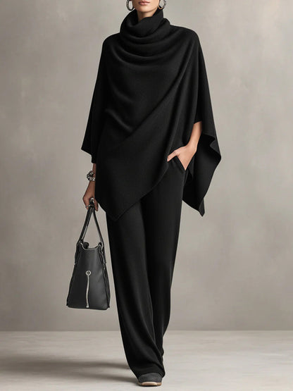 Black draped cowl-neck top with asymmetrical cape sleeves and wide-leg trousers