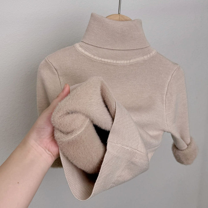 Beige fleece-lined knit sweater with ribbed turtleneck; plush lining visible in sleeve