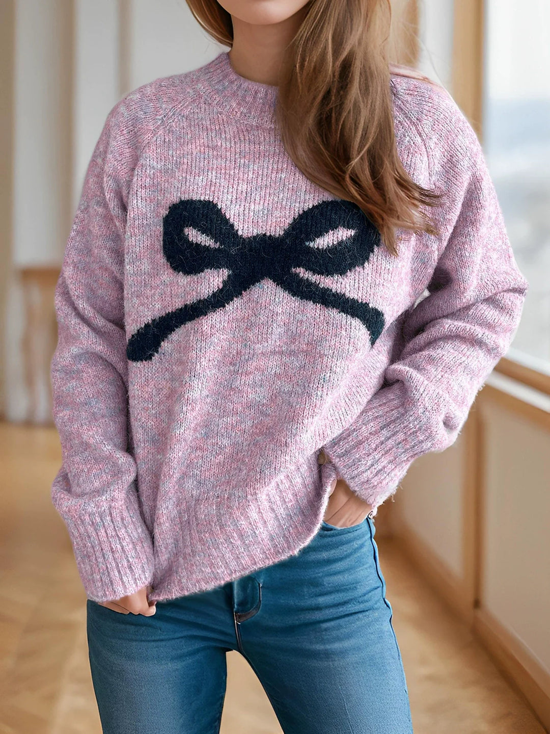 Mauve knit sweater with ribbed crew neck, cuffs, and oversized dark bow intarsia