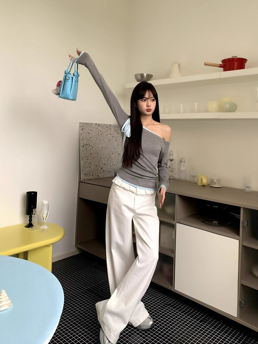 White high-waisted wide-leg jeans with pleated details and lace-trim ruffled waistband
