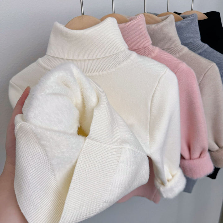 White fleece-lined knit sweater with ribbed turtleneck; plush lining peeks from sleeve
