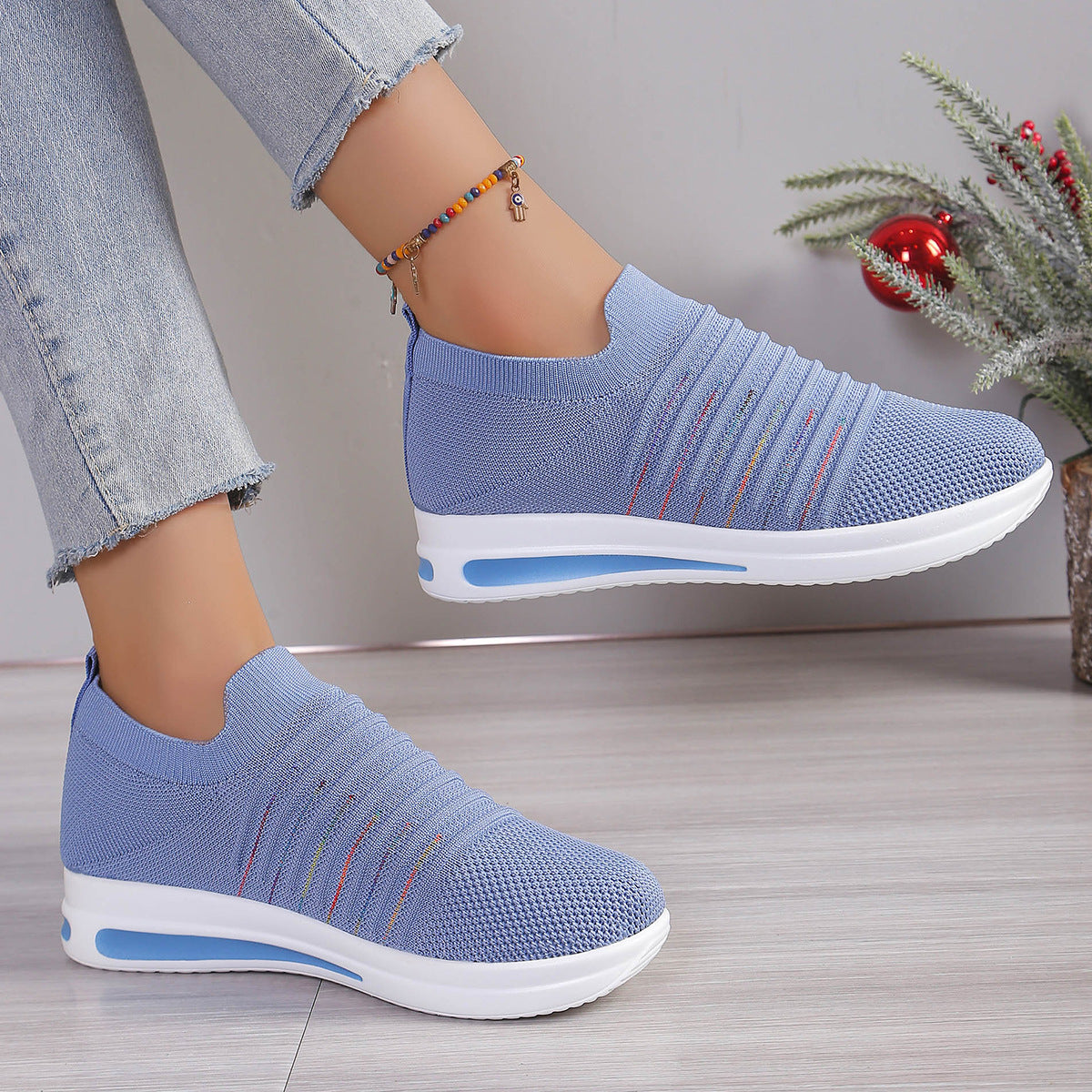 Blue knit slip-on sneakers with multicolor stripe detail and white platform sole