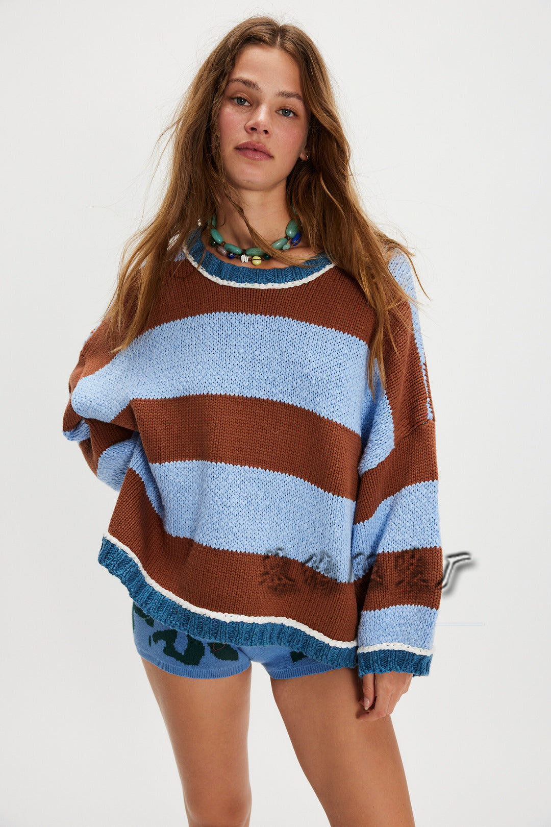 Striped crew neck sweater in blue, brown, and light stripes with ribbed cuffs and hem.