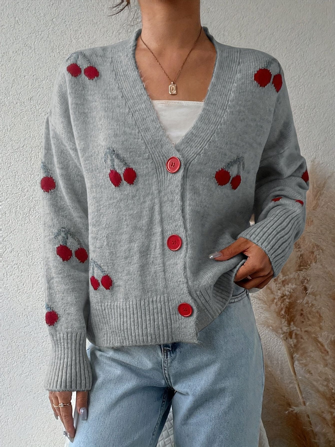 Gray button-front cardigan with red cherry motifs, round red buttons, ribbed hem