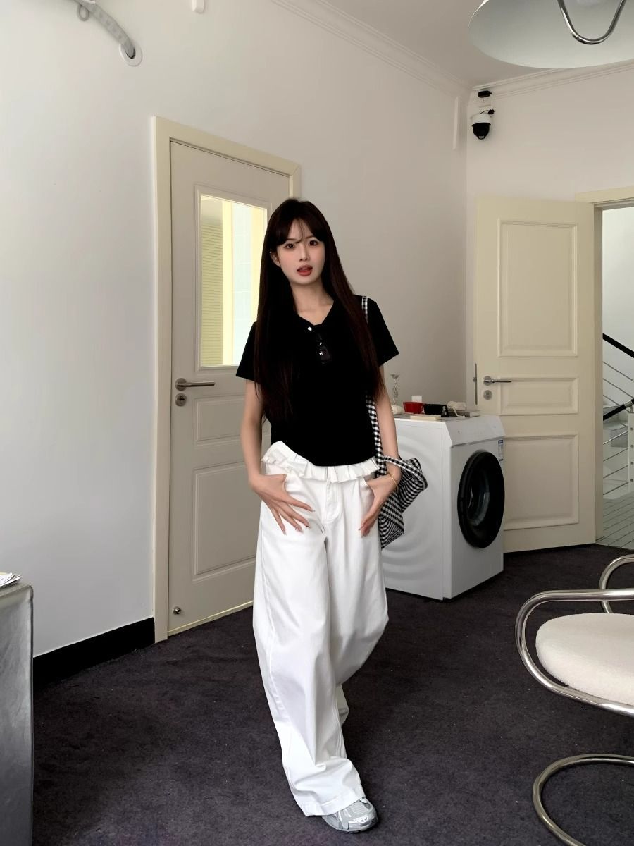 White wide-leg jeans with pleated front, button waist, and lace-trim ruffle