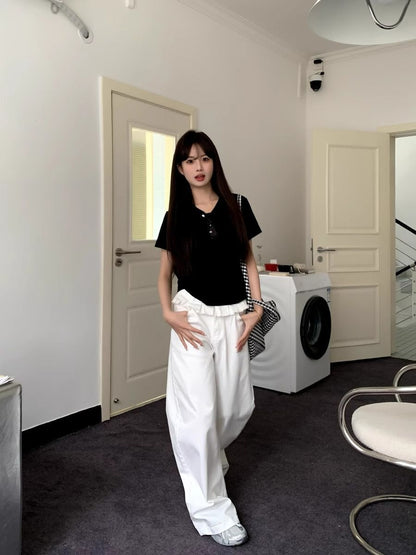 White wide-leg jeans with pleated front, button waist, and lace-trim ruffle