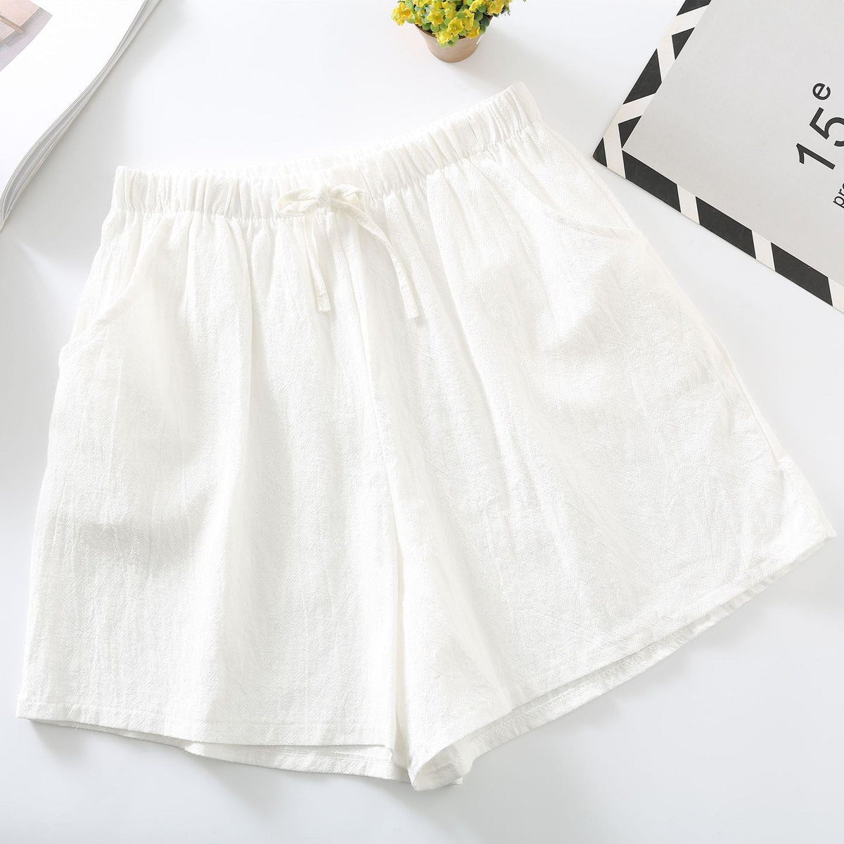 White relaxed-fit shorts with elastic waistband and drawstring tie