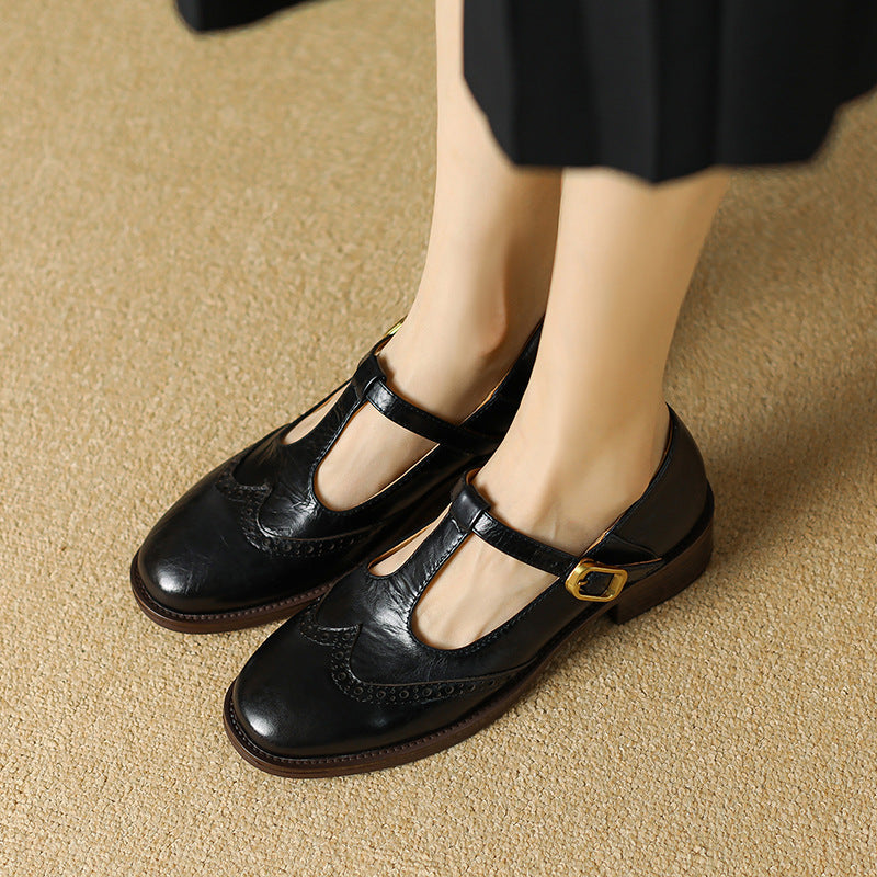 Black Mary Jane shoes with buckle strap and perforated toe detail