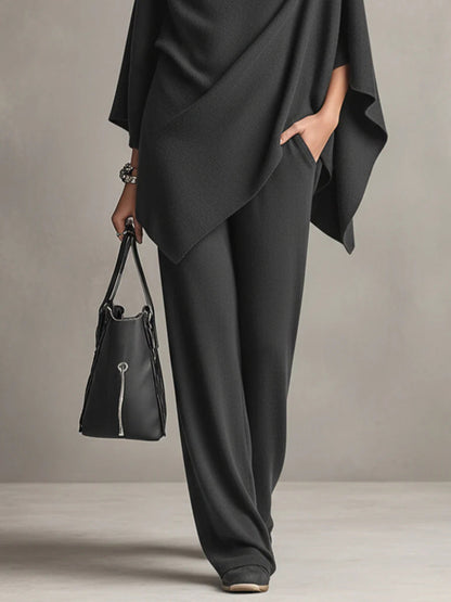 Black wide-leg trousers with draped cowl-neck cape top and flowing side panel