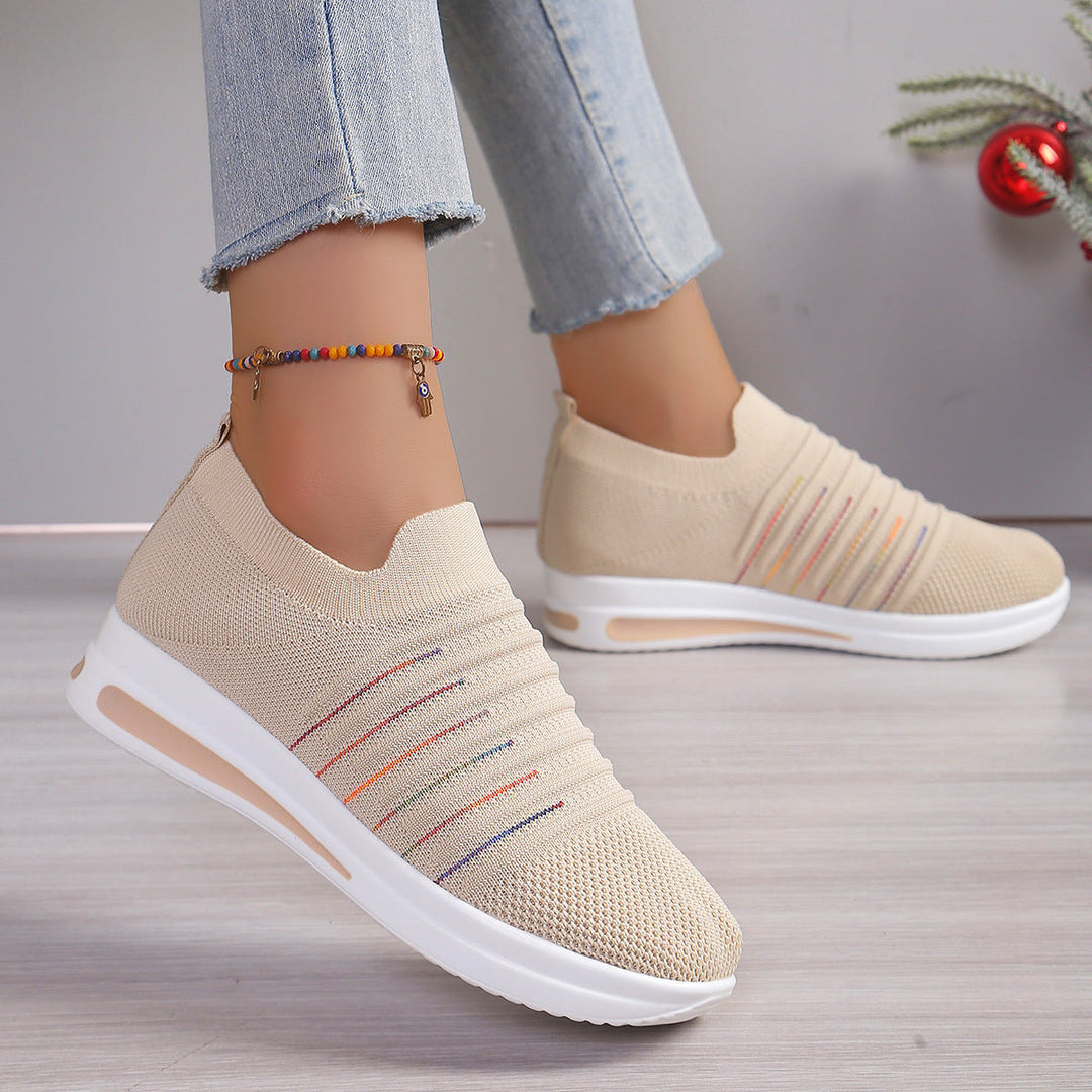 Beige knit slip-on sneakers with multicolor stripe detail and white sole, side view
