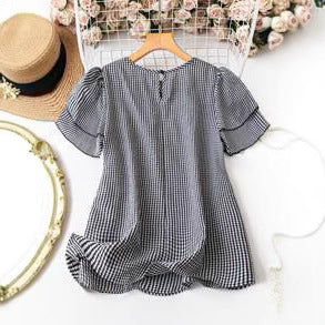 Black-and-white checkered peplum-style blouse with short puff sleeves and gathered hem