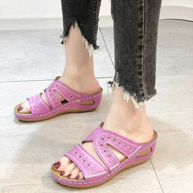 Orthopedic sandals in pink-purple with decorative cutouts, open toe and strap.