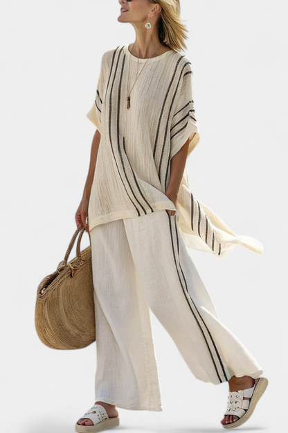 Ivory linen blouse and black-striped trousers, draped wide-leg silhouette