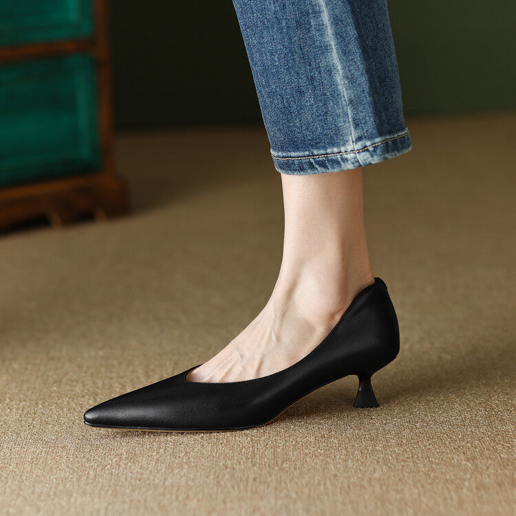 Black pointed-toe pumps on foot, low block heel and smooth upper