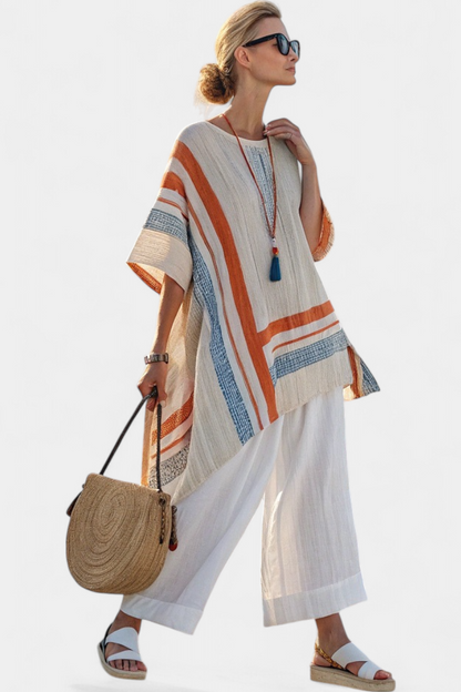 Contrast-striped linen blouse with stepped hem over white wide-leg trousers