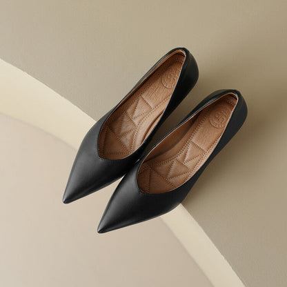 Pair of black pointed-toe pumps showing beige patterned lining inside
