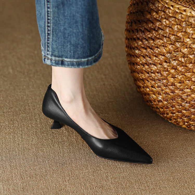 Black pointed-toe pumps with low block heel, side view with denim cuff