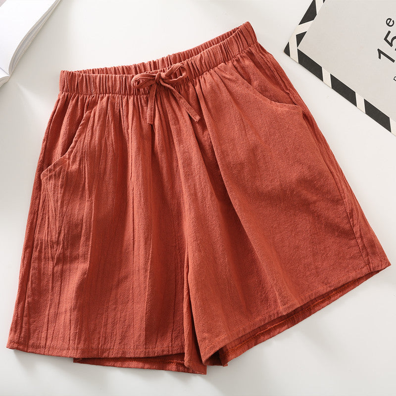 Rust red relaxed-fit shorts with elastic waistband and drawstring tie