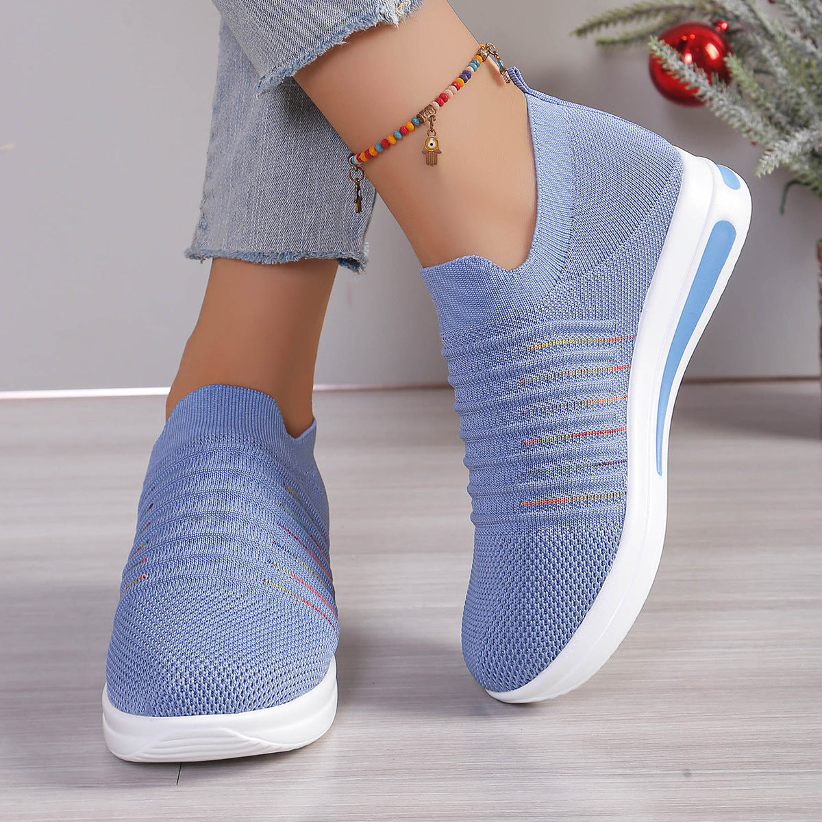 Blue knit slip-on sneakers with multicolor stripe detail and white platform sole