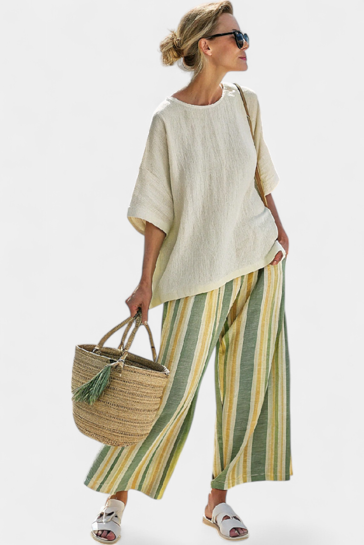 Beige linen top with wide sleeves and high-low hem, paired with striped wide-leg trousers