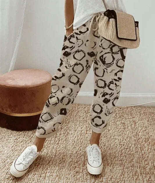 Printed retro comfort pants, light base with black abstract shapes, tapered leg cuffs