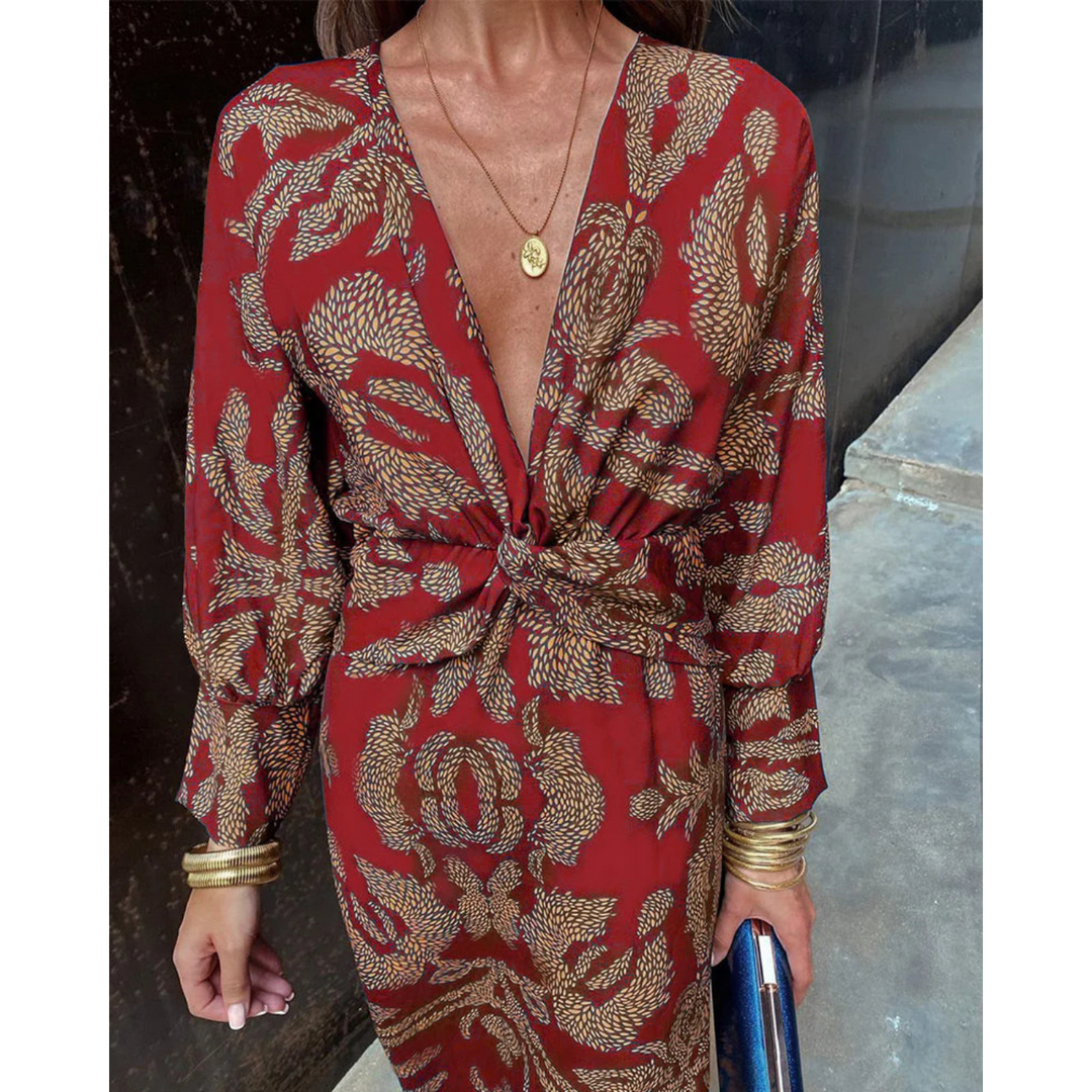 Boho elegance dress close-up: red fabric with gold print, deep V-neck, knotted waist