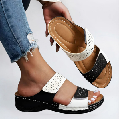 Orthopedic sandals in white and black with perforated straps and hook-and-loop closure