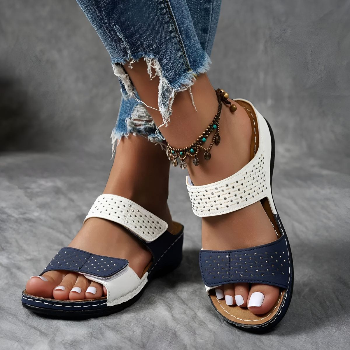 White and navy orthopedic sandals with perforated straps and adjustable hook-and-loop