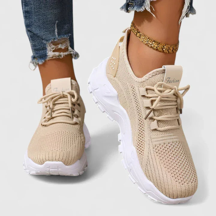 Beige orthopedic sneakers with knit upper, lace-up front, and chunky white soles.