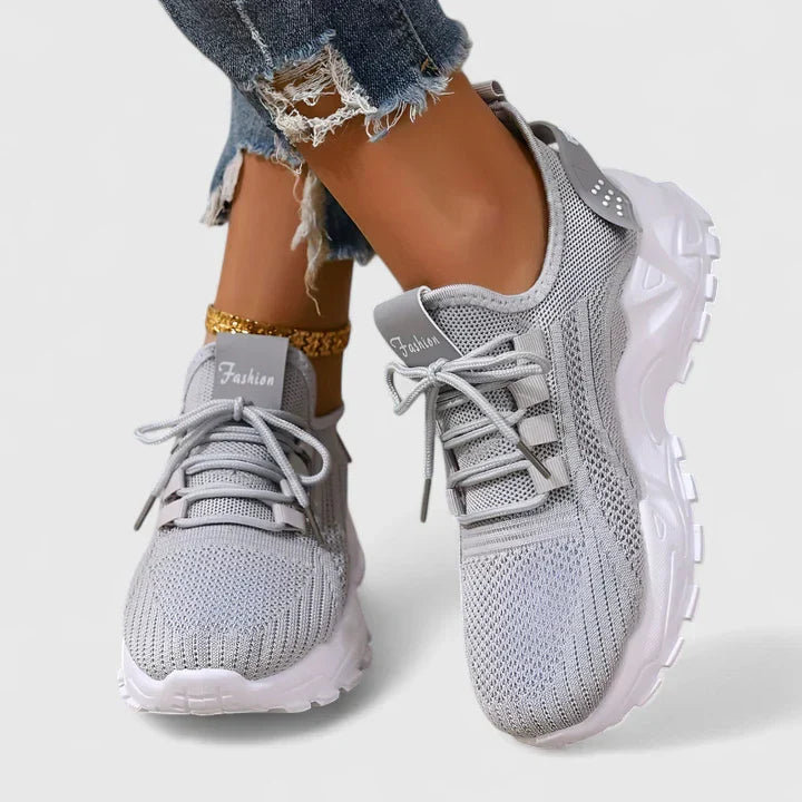 Gray orthopedic sneakers with breathable knit upper, lace-up front, and white cushioned sole.