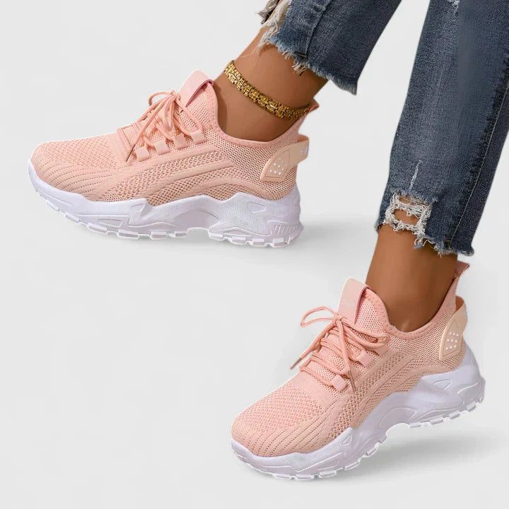 Pink orthopedic sneakers with knit upper, lace-up front, and cushioned white soles.