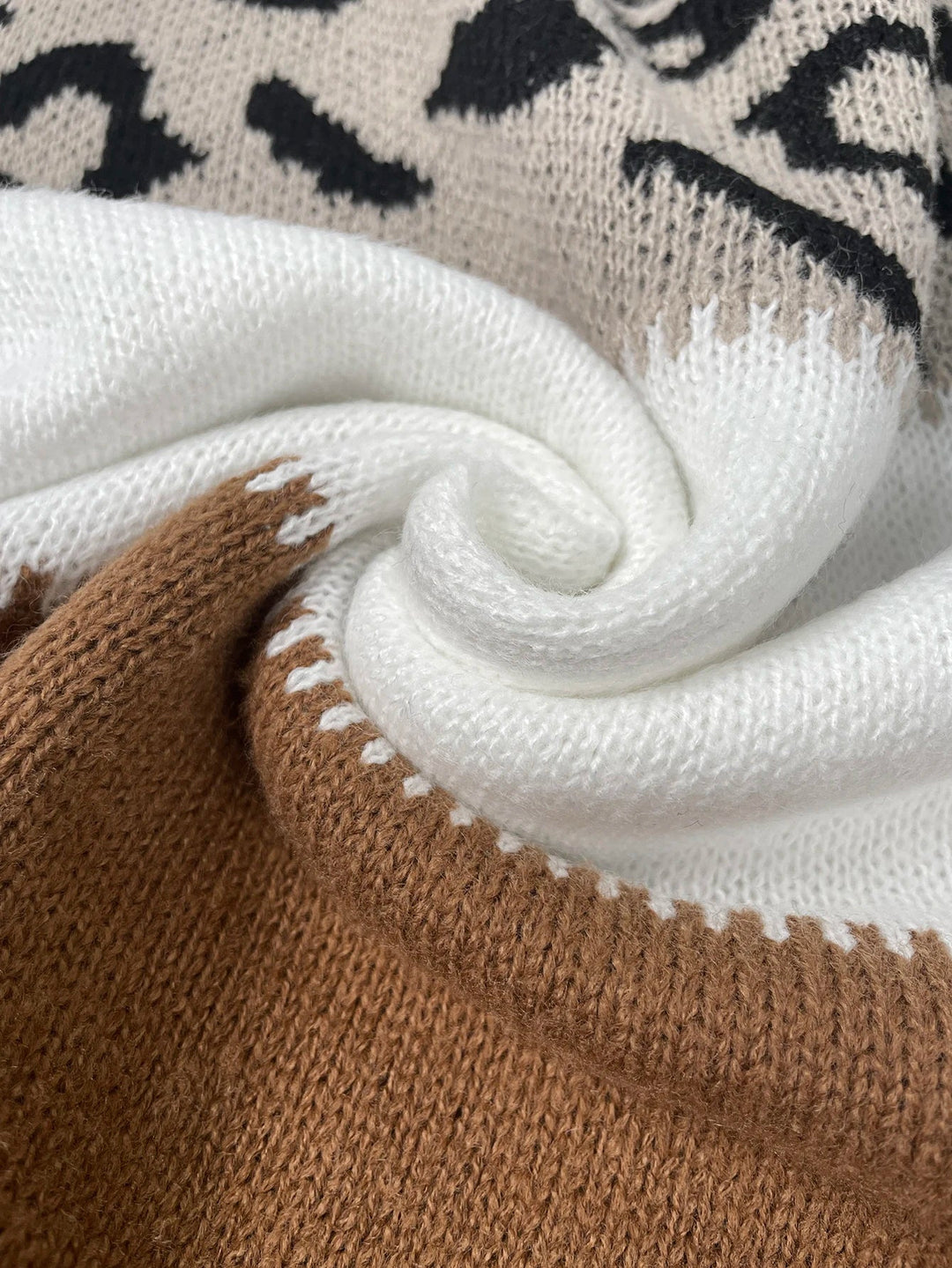 PANTHERA™ knit sweater close-up with black spot pattern and white collar and cuff trim