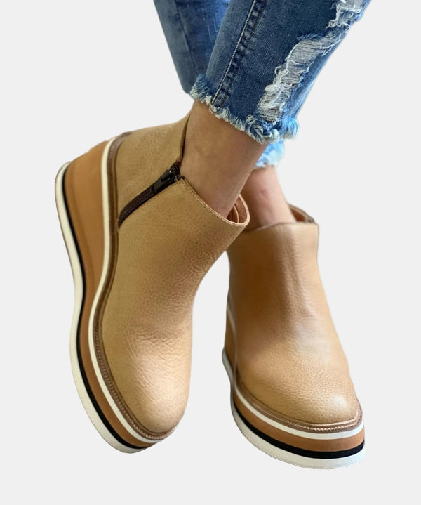 Tan ankle boots with side elastic, pull-on look, and platform heel with striped sole.