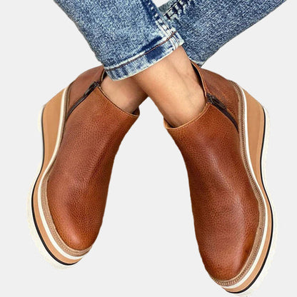 Brown ankle boots with side elastic, slip-on style, and platform sole with striped trim.