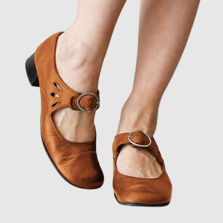 Brown leather Mary Jane flats with oval cutout strap and round metal buckle