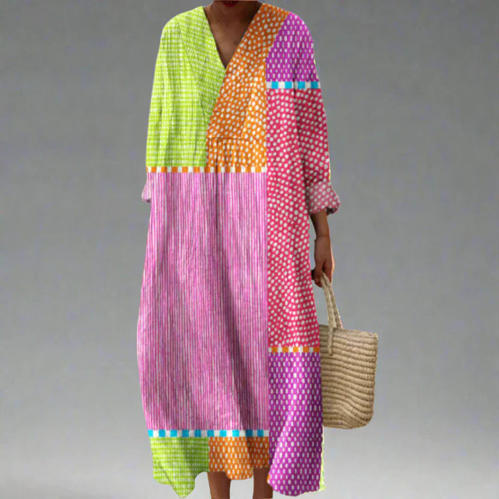 Geometric patchwork dress with long sleeves, V-neck, multicolor blocks and stripes.