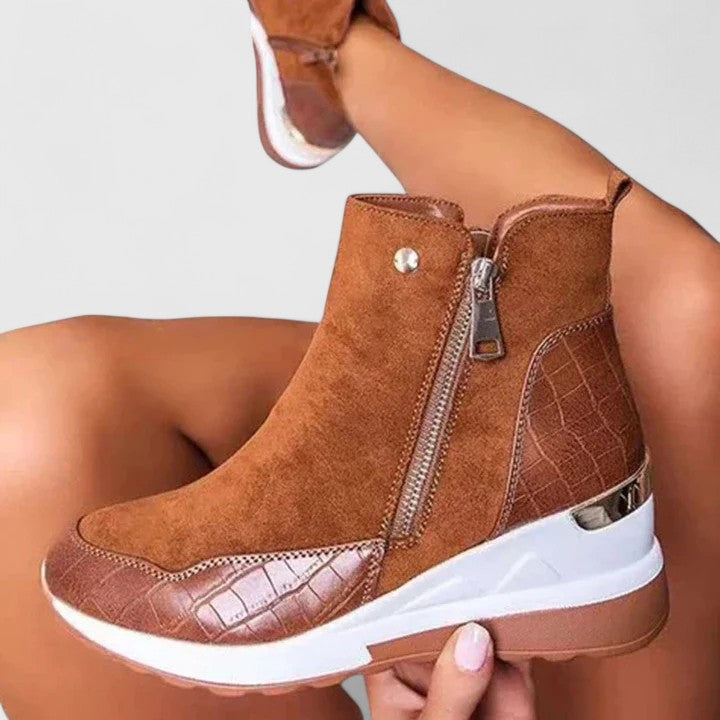 Brown orthopedic ankle boot close-up with side zipper and white sole.