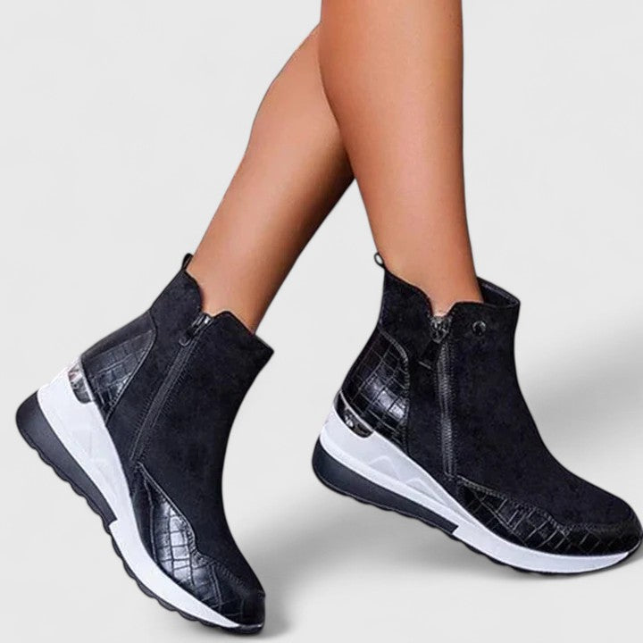 Black orthopedic ankle boots with side zipper and textured panels on white sole.