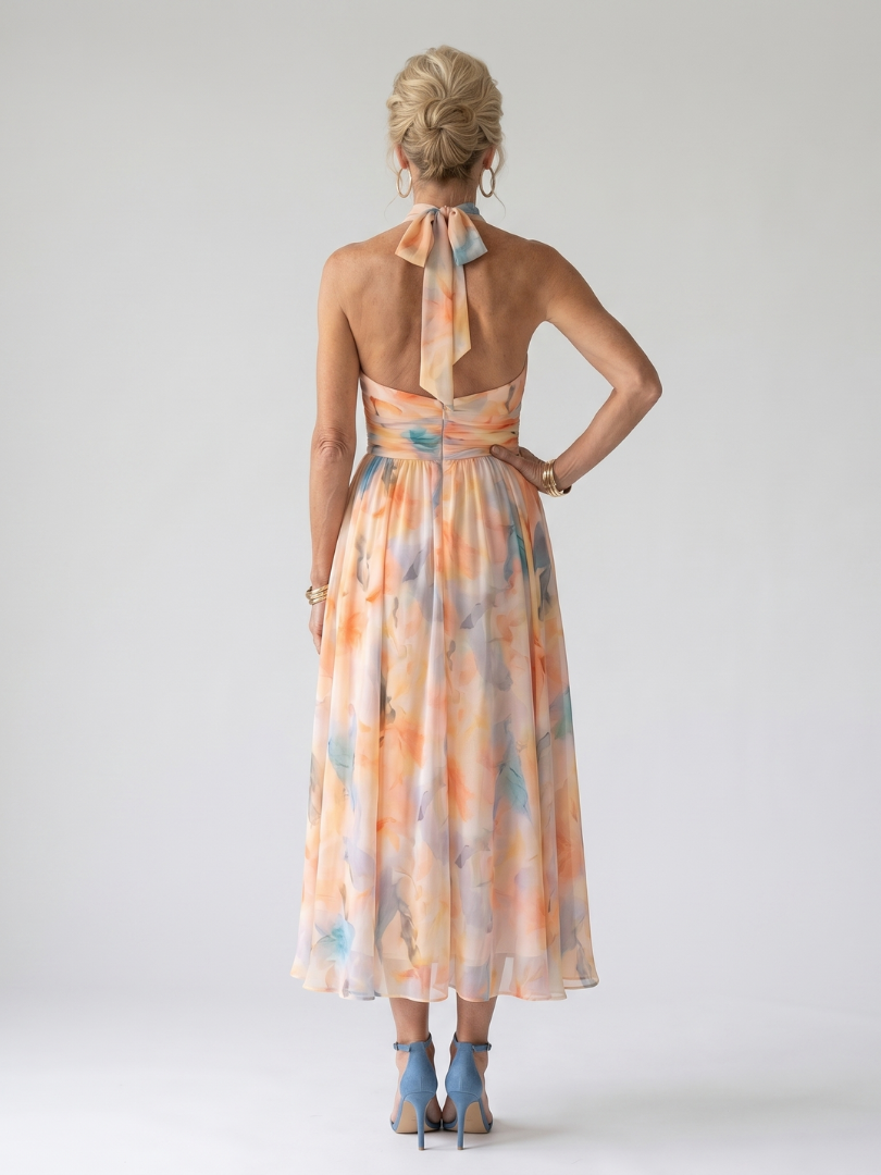 Soft halter midi dress with open back and tied halter, peach-and-blue watercolor print